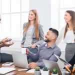 A group of people around a table, attending a good meeting.