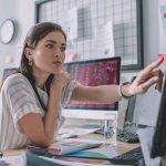 Woman at desk reviewing metrics.